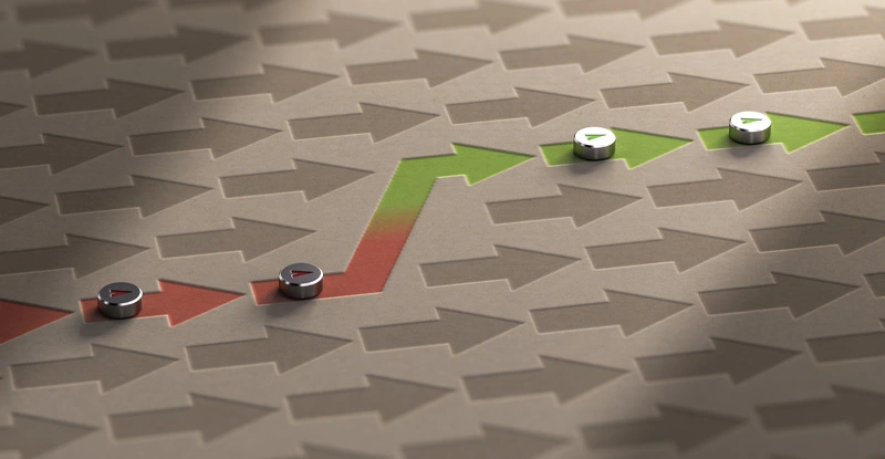Arrows on a brown background with one path of arrows going from red to green