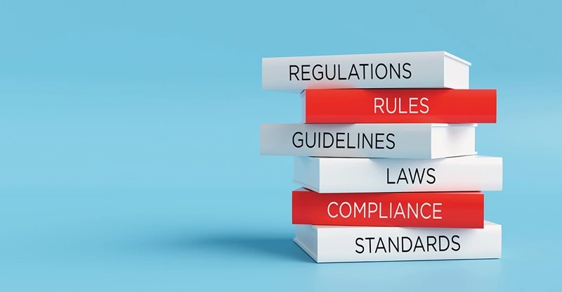 Stack of books representing regulatory compliance and legal standards