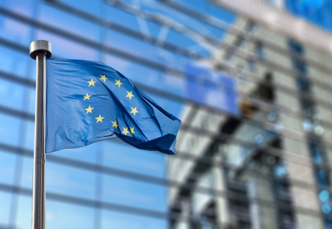 European Union Flag flying full mast against background of EU building